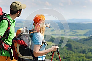 Hiking young couple point at panoramic view