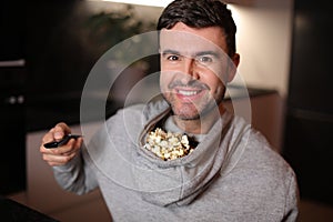 Hilarious man using the hood of the hoodie to store his popcorn while watching tv