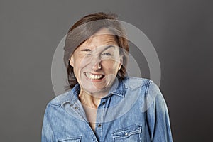 Hilarious middle aged woman showing teeth in trying to wink