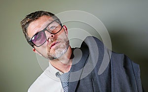 Hilarious portrait of 40s weird and wasted businessman in suit and tie wearing ridiculous big broken nerdy glasses posing