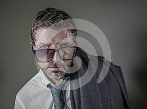 Hilarious portrait of 40s weird and wasted businessman in suit and tie wearing ridiculous big broken nerdy glasses posing