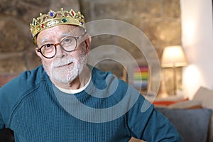 Hilarious senior man with brat expression wearing a crown