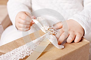 Ð¡hild`s  hands holding gift box. Christmas, hew year, birthday concept. Festive background with bokeh and sunlight. Magic fairy