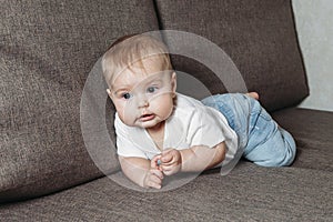 Hildhood babyhood and people concept happy smiling little baby boy or girl crawling on sofa