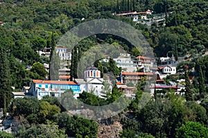 a hill with buildings and trees all around it and a building with two stories