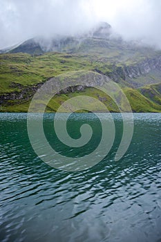 Hill and colorful water at Bachalpsee near First, Switzerland