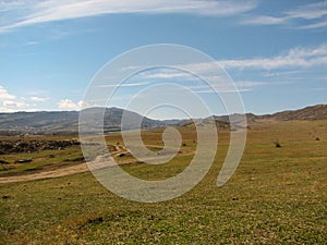 Hill covered of yellow grass under clear blue sky