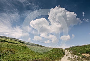 Hill landscape with deep blue sky and big cloud