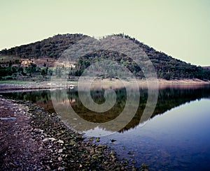 Hill and landscape reflecting in lake Windamere Dam New South Wales Australia at blue hour