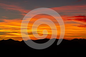 Hill silhouettes under a cloudy sky during a breathtaking sunset in Patagonia, Argentina