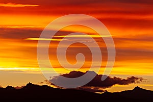 Hill silhouettes under a cloudy sky during a breathtaking sunset in Patagonia, Argentina