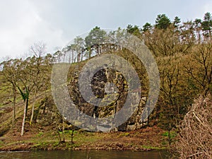 Hill slope with rocks and trees along Ourthe river, Liege, Belgium