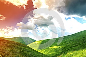 Hills with green grass and blue sky with white puffy clouds