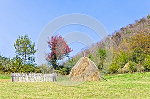 Hills on mount Bobija, small wooden fence, haystack and colorful trees