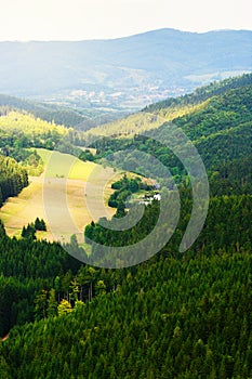 Hills and sunny valley in the Stone Mountains. Vast panorama of picturesque countryside landscape in Sudetes, Poland. Aerial view.