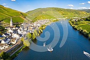 Hills with vineyards and church in Merl village of Zell Mosel town, Rhineland-Palatinate, Germany. Water skiing, barges photo