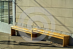 Hillside bench with uneven legs for passersby and pedestrians to sit and rest in modern downtown city neighborhood