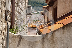 Hillside homes through view-shaft between apartment buildings and orange rooftop tiles