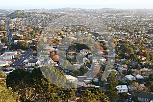 Hilltop vista of suburb with colorful trees in fall before sunset from Mount Eden, Auckland, New Zealand