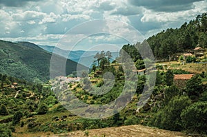 Hilly landscape covered by rocks and trees with rustic houses