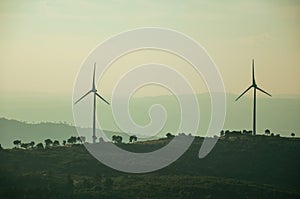 Hilly landscape with wind turbines on sunset