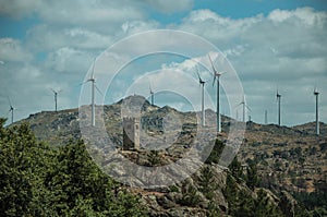 Hilly landscape with wind turbines on top