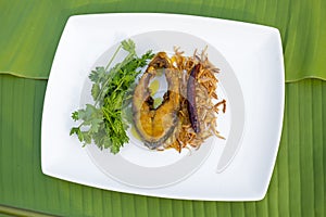 Hilsa fish fry, onion and dried chilly with Coriander leaf in plate.