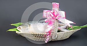 A Hilsha fish in a boat-shaped handmade busket used as a gift hamper in festive occations such as Jamai Shashthi.