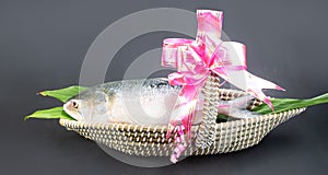 A Hilsha fish in a boat-shaped handmade busket used as a gift hamper in festive occations such as Jamai Shashthi. photo