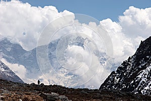 Himalaya cloudscape with trekker in foreground, Nepal