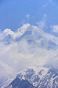 Himalaya Machapuchare mountain peak in cloudy blue sky, Nepal