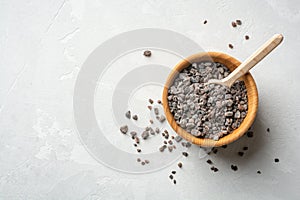 Himalayan or Indian black salt in wooden bowl on grey concrete background