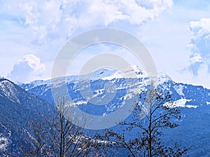 Himalayan Landscape - White Snowy Peaks of Blue Mountains, Trees, and White Clouds in Sky - Uttarakhand, India