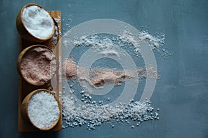 Himalayan pink salt, fine salt and coarse salt in crystal stones in wooden bowls