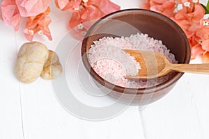 Himalayan pink spa salt in a clay bowl on a white background. Massage, aromatherapy