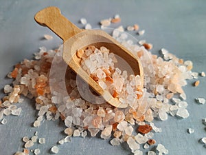 Himalayan salt, coarse salt in wooden spoon, selective focus. Thick pink crystals.