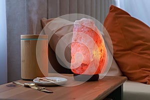 Himalayan salt lamp, air ionizer and accessories on nightstand in bedroom photo