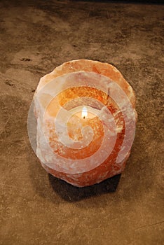 Himalayan Salt Lamp Candle Lit on stone