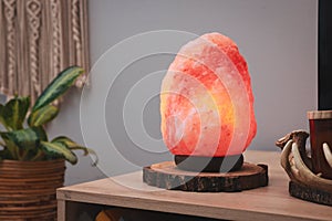 Himalayan salt lamp on wooden table indoors