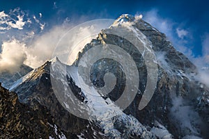 Himalayan summit Pumori against a blue sky with clouds. Everest