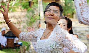 Hindu celebration at Bali Indonesia, religious ceremony with yellow and white colors, woman dancing.