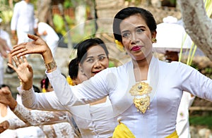 Hindu celebration at Bali Indonesia, religious ceremony with yellow and white colors, woman dancing.