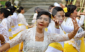 Hindu celebration at Bali Indonesia, religious ceremony with yellow and white colors, woman dancing.