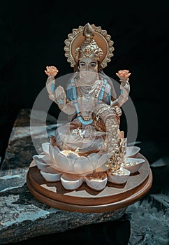 Hindu cosmos Maha laxshmi statue decorated with Flower Garland. Statue of Goddess of Wealth
