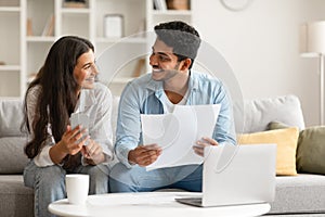 Hindu couple planning finances with documents and laptop