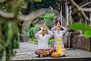 hindu couple put their hand on top of their head doing the prayer at pura