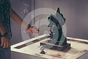 Hindu god Ganesh on black background. Statue on wooden table