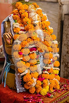hindu god ganesha idol worshiped with flowers vertical shot from flat angle
