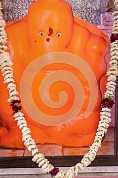 hindu god ganesha idol worshiped with flowers vertical shot from flat angle