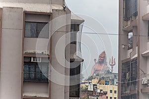 hindu god lord shiva isolated statue through building gaps at morning from different angle